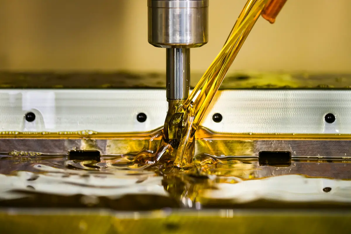 CNC milling endmill flooded with golden coolant during precision machining